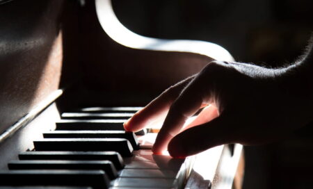 ピアノの鍵盤に触れる指のアップ画像